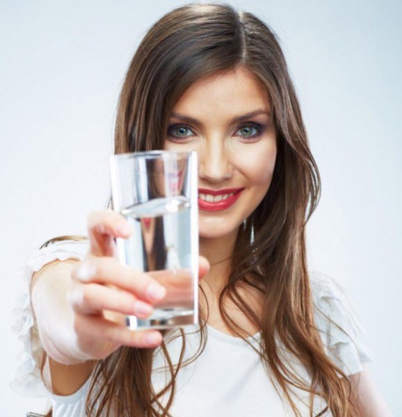 Девушка протягивает стакан воды.